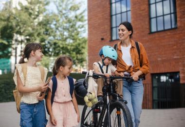 kvinde henter børn på cykel